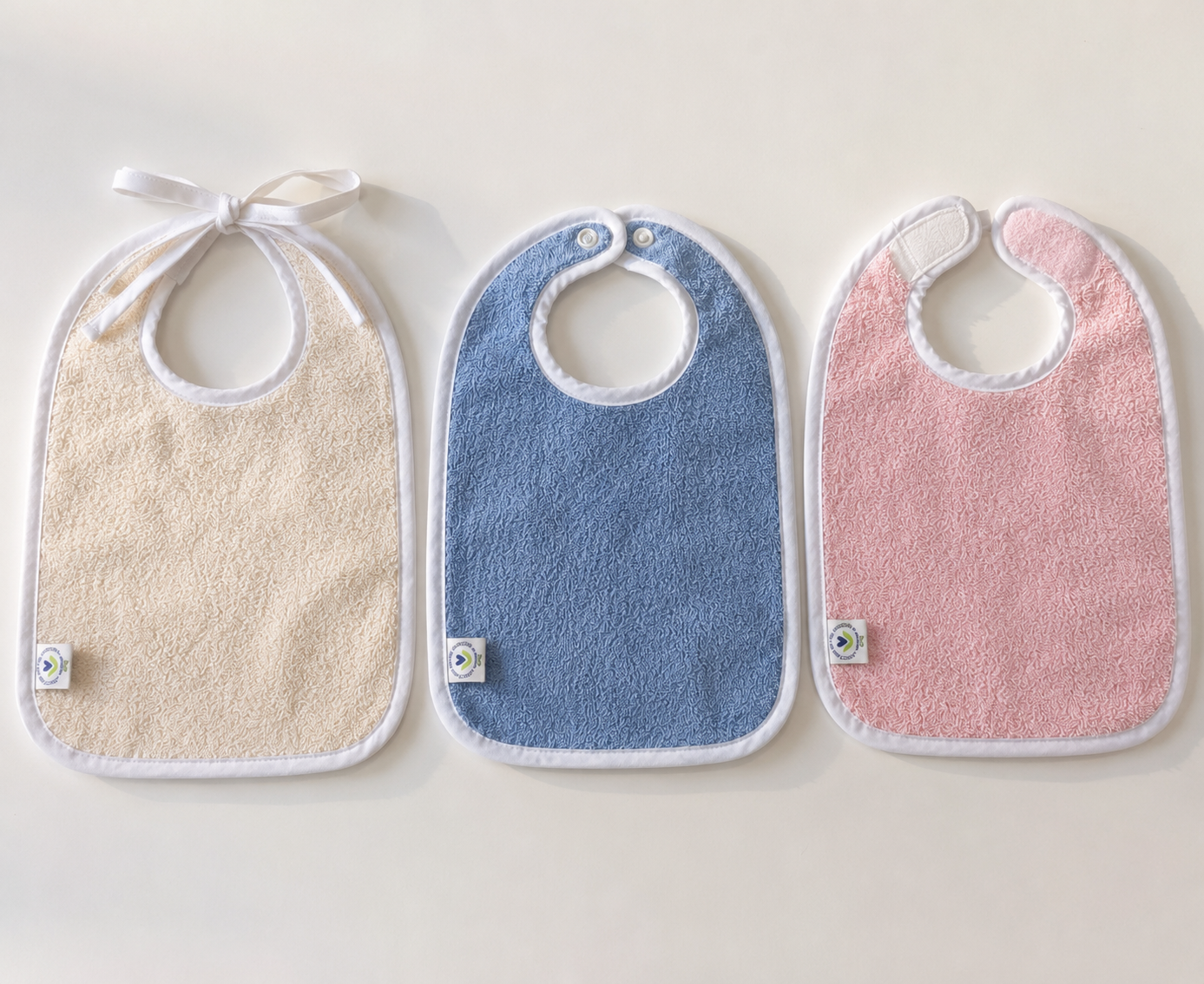Baby bibs in combed cotton terry with soft bound edge, in natural, blue and pink